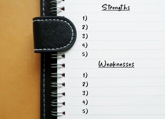 Notebook with handwritten text STRENGTH  WEAKNESSES , concept of self reflection list making,...