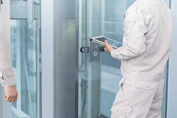 エレベーターの設備の点検　確認やメンテナンスをする作業員 © kapinon