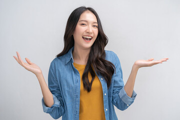 Smiling positive, attractive asian young woman, girl hand show product advertising in casual, portrait of beautiful brunette her with long hair, feeling happy standing isolated on white background.