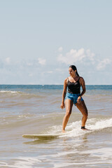 woman with surfboard on beach