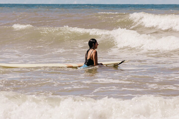 woman with surfboard on beach
