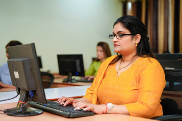 Indian woman working on computer at office.