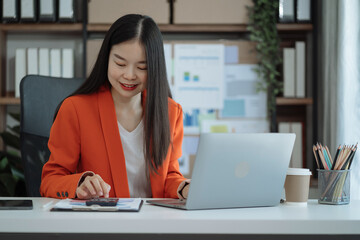 Business woman working on laptop and accounting financial report, accountant using calculator to calculate tax refund at office.