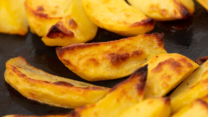 Potatoes baked in the oven as a background.