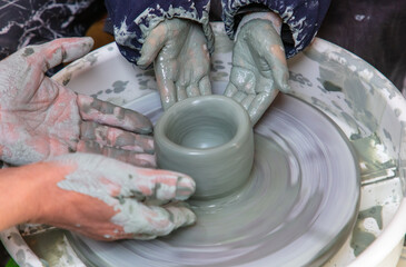 Hands of a potter, creating an earthen jar