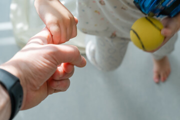 Little child's hand holding father's finger