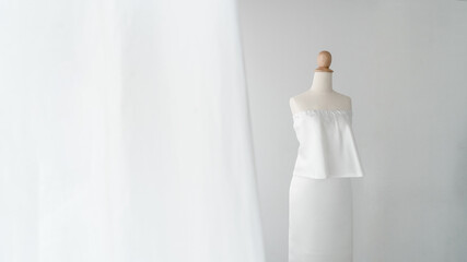 A female mannequin in white dress at showroom shop