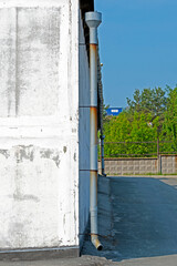Drainpipe on the wall of a building on a summer day
