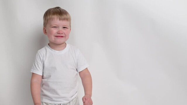 Little boy kid gets angry, hysterics close-up on white background. Concept naughty child