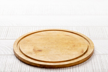 Wooden cutting board on white kitchen table