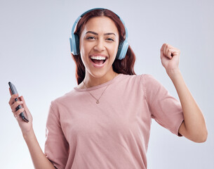 Mobile, portrait or happy woman in headphones dancing music or radio audio in studio on white background. Dance, singing or girl streaming or listening to song playlist in freedom with cellphone