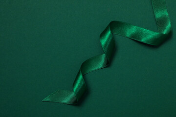 Concept of different ribbons, green ribbon on green background