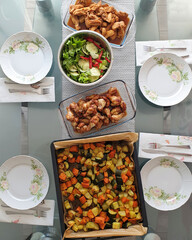 high angle view of healthy food on table with cooked chicken and roast vegetables in baking tray