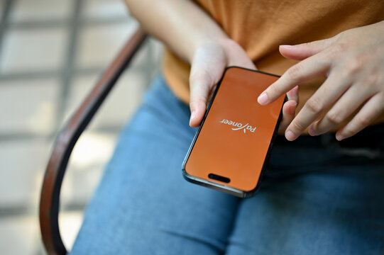 Close-up image of a female using Payoneer app on her iPhone.