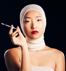 Woman, portrait and plastic surgery with syringe, bandage and studio background with asian beauty for filler. Female person, face and cosmetology with injection for skin, collagen and treatment.