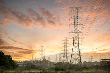 High-voltage pylons supply electricity to areas outside the city. High voltage pylon with sunset background