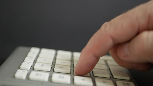 Blurred Shooting with a Businessman in the Office Making Financial Calculations Using a Computer Keypad. An employee in a Financial Corporation Using the PC Keypad. 