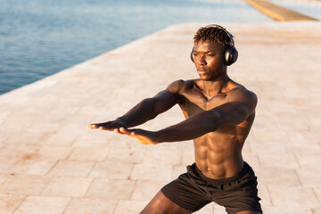 Fototapeta na wymiar Fitness training outdoors. Handsome African man doing exercises outside. Muscular man training.