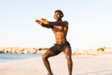 Fitness training outdoors. Handsome African man doing exercises outside. Muscular man training.