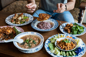 Table meal in Asian style. Man having Thai traditional style meal. 