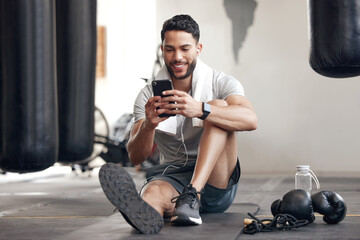 Fototapeta na wymiar Fitness, man with smartphone and earphones at the gym happy for training or health wellness. Meditation or commitment, exercise or workout and male athlete listen to music or podcast for motivation