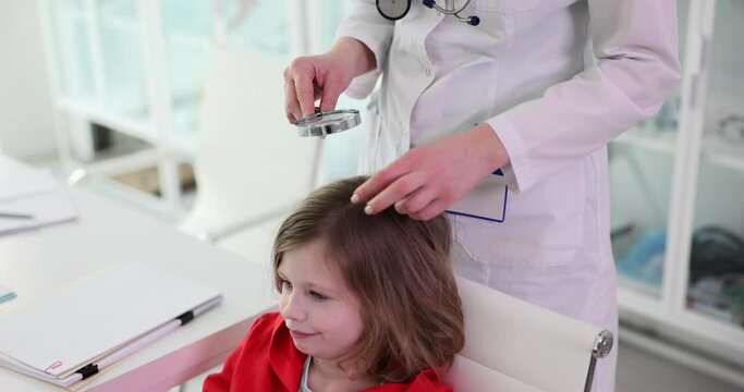 Trichologist examines condition of child girl hair. Lice nits and dandruff in children