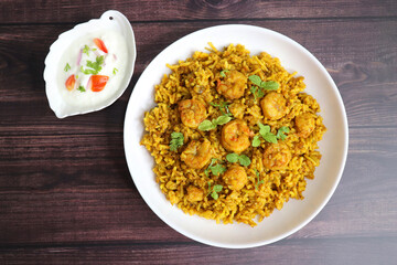 Prawns Biryani or shrimp Pulao. also called jheenga pilaf or jhinga biryani in India. known as Kolambi bhat in Marathi. Garnished with mint leaves, and coriander along with yogurt Raita. Copy space