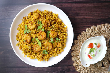 Prawns Biryani or shrimp Pulao. also called jheenga pilaf or jhinga biryani in India. known as Kolambi bhat in Marathi. Garnished with mint leaves, and coriander along with yogurt Raita. Copy space