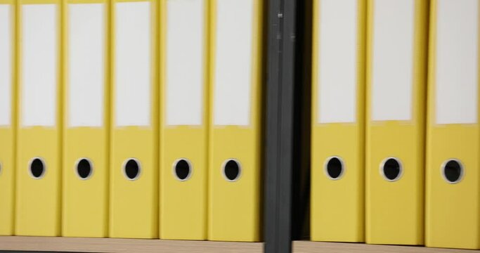 Yellow folders with folders and documents in long rows on shelves. Organized folder structure and archive