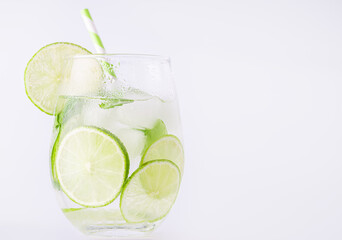Summer lemonade with basil and lime on white background. One fresh summer cocktail with basil,...