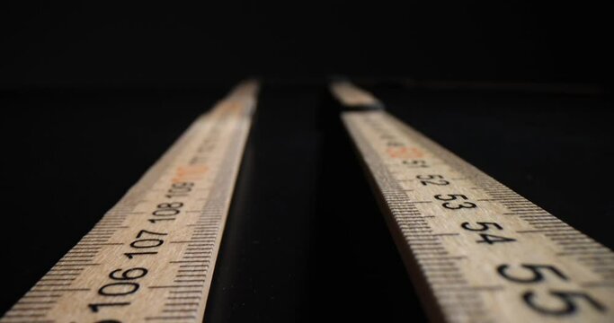 Closeup of wooden ruler on black background. Folding wooden ruler