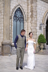 Fototapeta premium The wedding photos of a western male and Vietnamese women in outdoor settings