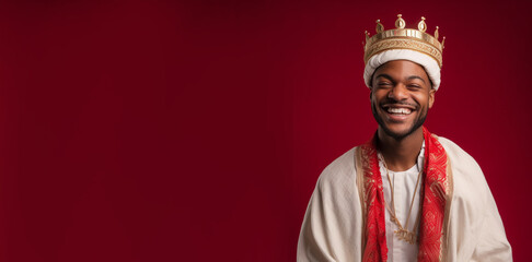Obraz premium a smiling young male dressed as a king's in front of red background generative ai