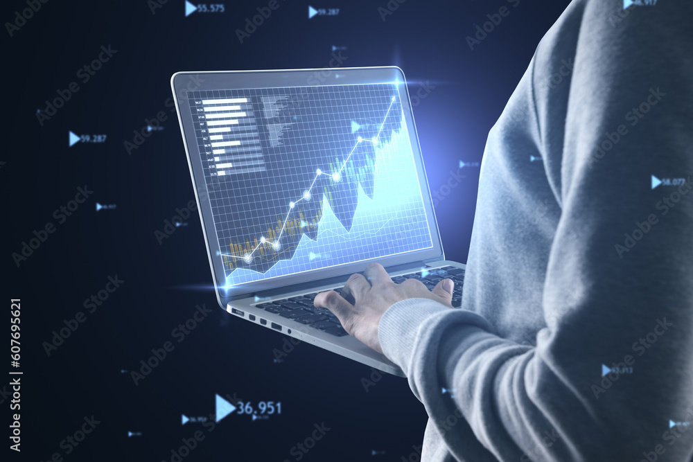 Poster Close up of hands using laptop keyboard with glowing business graph hologram on blurry blue background. Financial growth and analysis concept.