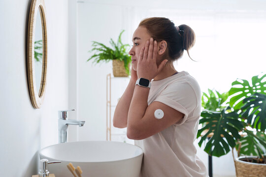 Woman with diabetes touching face in bathroom at home