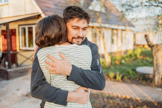 Couple embracing in yard with house in background