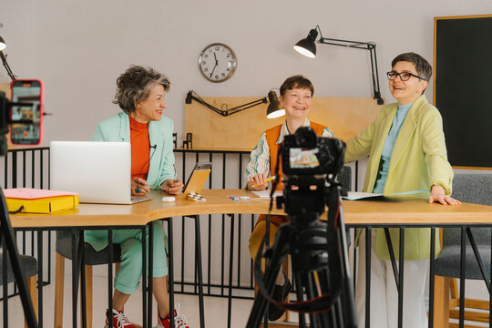 Three women sitting in studio and recording video on the camera