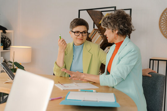 Two women sitting in studio talking while recording online video