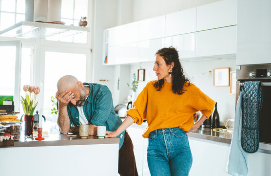 Serious woman arguing with man in kitchen at home