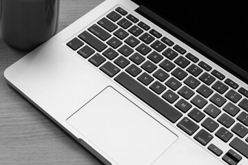 A laptop and a cup are placed on the table. meeting time