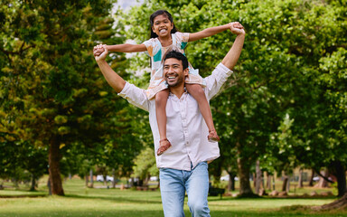 Naklejka na ściany i meble Indian dad, daughter and shoulders in park with smile, airplane game or piggyback in nature on holiday. Man, girl and playing together in garden, woods and summer sunshine for happy family vacation