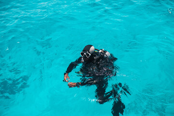Diving lesson in open water. Scuba diver before diving into ocean.