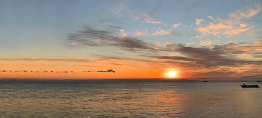 Naklejka premium 夏の海に沈む黄昏の夕日と漁船
