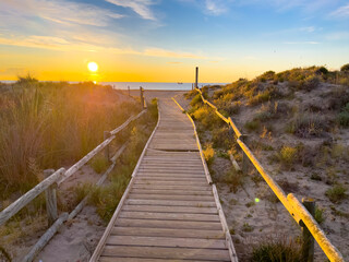Wooden walkway to the beach at sunset