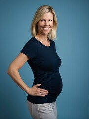Portrait of a happy pregnant woman smiling at the camera against a blue background