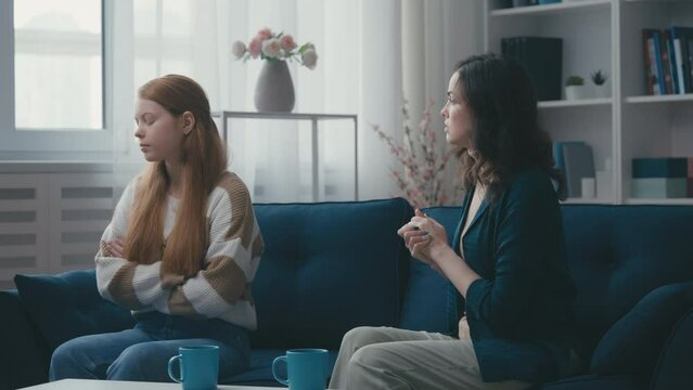 Strict middle-aged mother scolding teenage daughter who's ignoring her, conflict