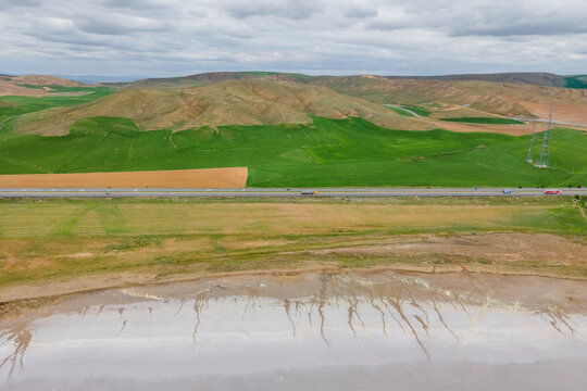 Aerial view of a road driving along the Tuz Golu (Lake Tuz), one of the largest hyper saline lake in the world, Central Anatolia Region, Turkey.