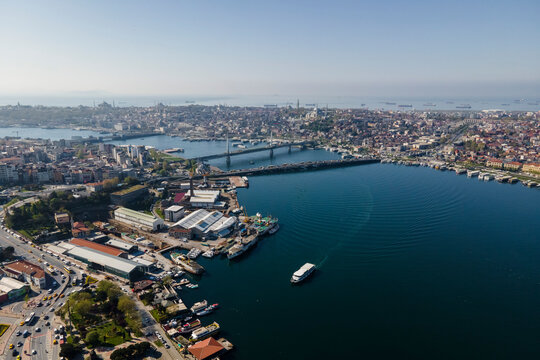 Aerial view of a boat sailing along the Golden Horn river estuary near the Galata bridge and the Ataturk bridge, Istanbul, Turkey.