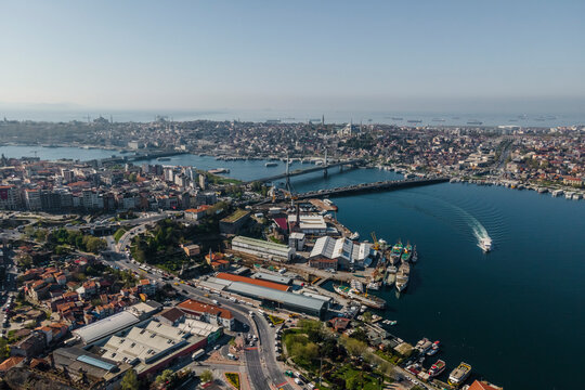 Aerial view of a boat sailing along the Golden Horn river estuary near the Galata bridge and the Ataturk bridge, Istanbul, Turkey.