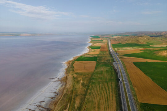 Aerial view of a road driving along the Tuz Golu (Lake Tuz), one of the largest hyper saline lake in the world, Central Anatolia Region, Turkey.